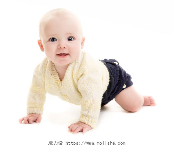 蓝眼睛的小男孩着一件黄色的毛衣和蓝色短裤爬着微笑的小孩婴儿微笑